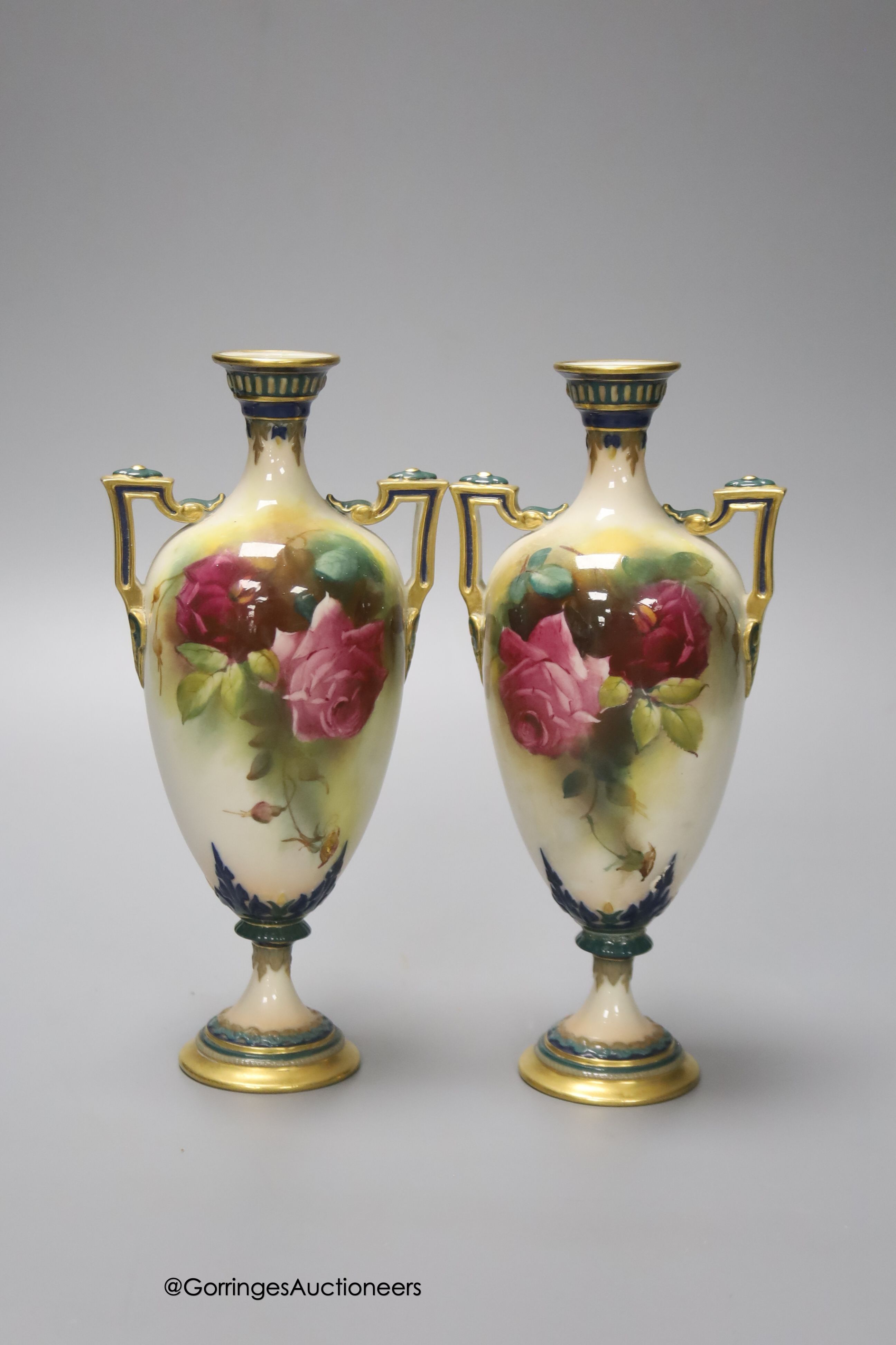 A pair of Royal Worcester two handled vases, decorated with roses, unsigned, 18cm (one a.f.)